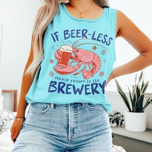 May include: A light blue tank top with the text "IF BEER-LESS please return to the BREWERY". The graphic features a pink lobster holding a beer mug. The tank top is sleeveless and made of a soft material.