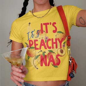 It's Peachy Graphic T-Shirt, Cute Fruit Shirt, Funny Summer Tee, Peach Lover Gift, Women’s Casual Top, Trendy Yellow Shirt
