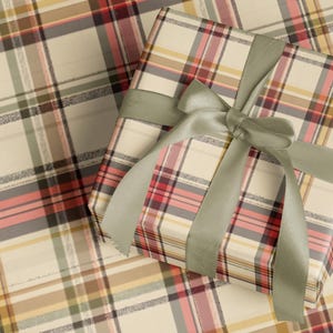 A gift box wrapped in a plaid pattern with a green ribbon tied around it.