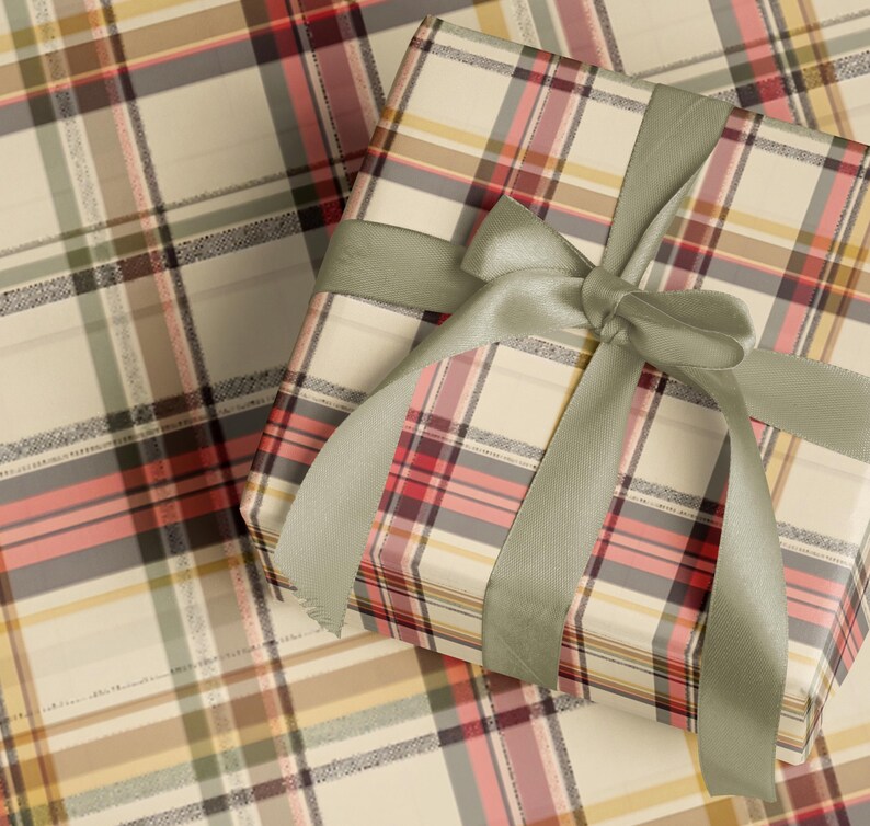 A gift box wrapped in a plaid pattern with a green ribbon tied around it.