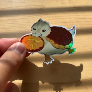 Metallic Rainbow Turtle duck Holding a White Lotus Tile Holographic Vinyl Sticker with Shiny Clear Protective Laminate