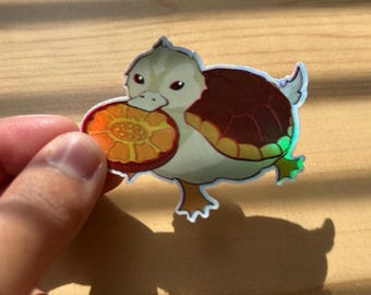 Metallic Rainbow Turtle duck Holding a White Lotus Tile Holographic Vinyl Sticker with Shiny Clear Protective Laminate