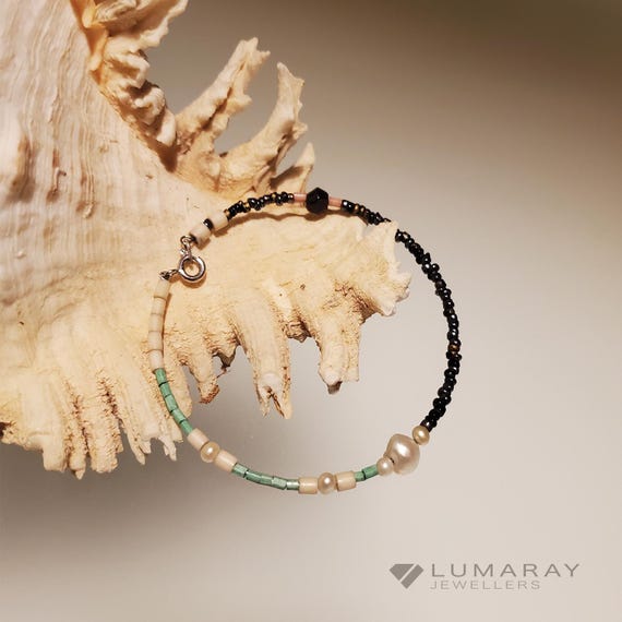 Bracelet range with a 925 silver catch is hand made with a variety of beads including river pearls,  glass and resin threaded through.