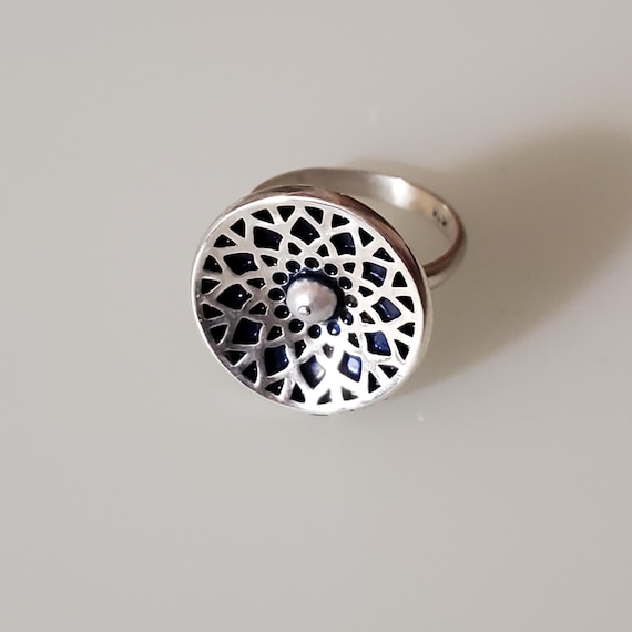 This gorgeous flower ring is all hand made from 925 Sterling Silver and filled with cold enamel.  The piece includes a small river pearl.