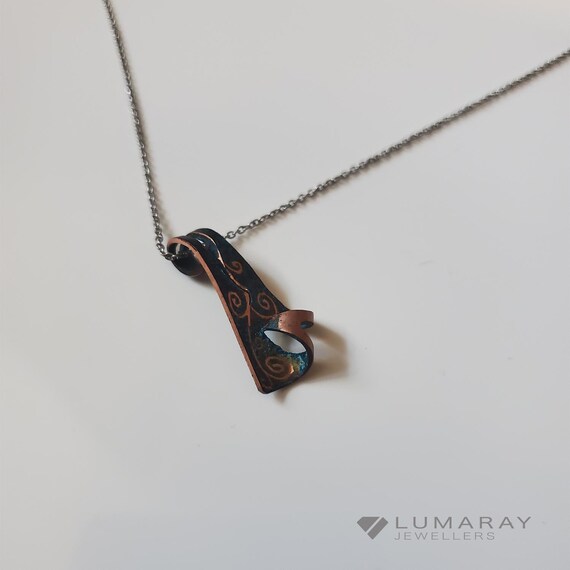 Pendant out of patinated, textured and engraved copper, is crafted to reflect my style of work.  It comes with a 925  chain.
