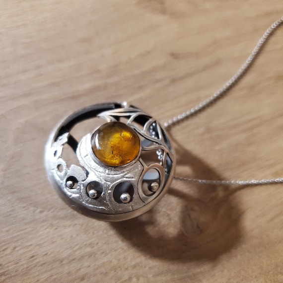 Pendant out of 925 silver is set with a Baltic Amber, and is all hand made.  It comes with a 925 Sterling Silver 45cm chain. Great gift