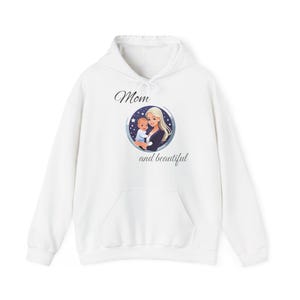 May include: White hoodie with a graphic print of a woman holding a baby. The graphic is in a circle with the text "Mom and beautiful" below it.