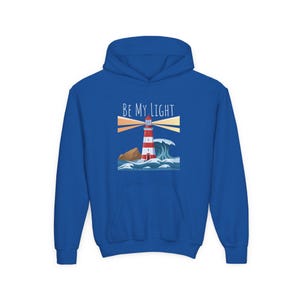 Puede incluir: Una sudadera con capucha azul real con un gráfico de faro y el texto "BE MY LIGHT" en blanco.