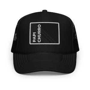 May include: Black trucker hat with a rectangular patch embroidered with the words "PAPI CHURRO" in white. The hat has a black brim and mesh back.