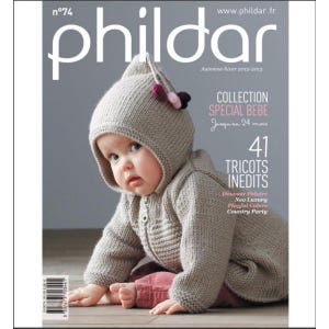 Op de afbeelding: Een tijdschriftcover met een baby die een gebreide trui met capuchon en een muts draagt. Het tijdschrift heet "Phildar" en bevat de tekst "Collection Special Bebe" en "41 Tricots Inedits".