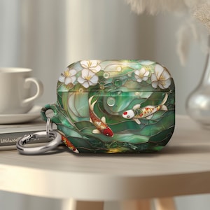 May include: AirPods case with a stained glass design featuring koi fish and white flowers. The case is primarily green with red, white, and gold accents. A silver carabiner clip is attached.