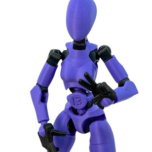 Close-up of a purple 3D-printed articulated action figure with black joints, making a peace sign with one hand.