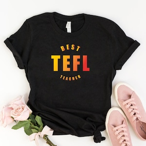 May include: Black t-shirt with the text "BEST TEFL TEACHER" in a gradient of yellow, orange, and red.