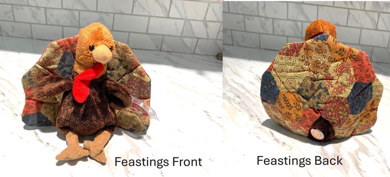 May include: A plush turkey toy with a brown body, tan feet, and a red wattle. The turkey's wings are made of patchwork fabric in shades of brown, red, and gold. The text "Feastings Front" and "Feastings Back" are visible.
