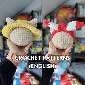 May include: Two crochet doll heads, one with a yellow hat and ears, the other with a red and white striped headband and ears. The text "CROCHET PATTERNS (ENGLISH)" is at the bottom. The doll heads are held in hands.