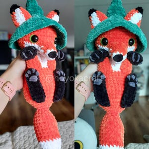 May include: A handmade crochet fox plushie in vibrant orange, white, and black, wearing a green hat. The fox has large, expressive eyes and is holding a pose. The text "@hoyokacraft" is visible. A charming, whimsical creation.