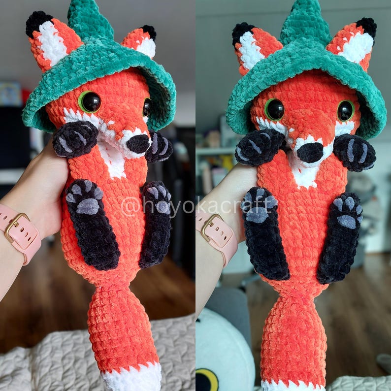 May include: A handmade crochet fox plushie in vibrant orange, white, and black, wearing a green hat. The fox has large, expressive eyes and is holding a pose. The text "@hoyokacraft" is visible. A charming, whimsical creation.