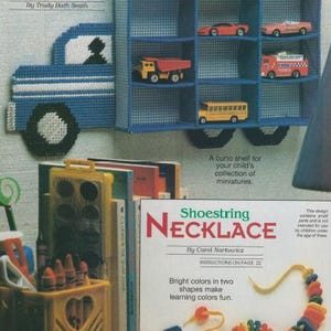 Puede incluir: Un proyecto de manualidades de lona de plástico para una caja de sombra de camión con un camión azul y estantes para coches en miniatura. El proyecto se titula "Truck Shadow Box" y es de Trudy Bath Smith.