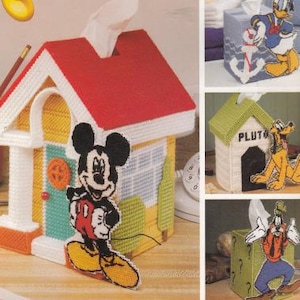 May include: A set of four tissue box covers featuring Disney characters. The covers are made of plastic canvas and feature Mickey Mouse, Pluto, Donald Duck, and Goofy. Each cover has a different design and color scheme.