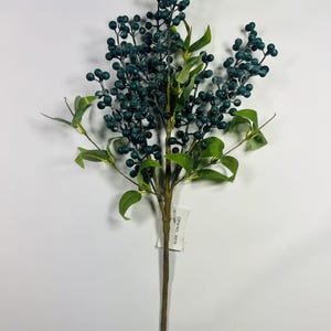 May include: A sprig of artificial greenery with dark green leaves and dark blue berries. The stem is brown and the sprig has a tag that reads "ITEM NO. 8978".