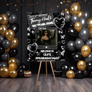 May include: A black and white birthday party sign on a wooden easel, with gold, black, and grey balloons. The sign reads "LILY'S 25TH BIRTHDAY" and "Throwing it back to the '99 and 2000s". A photo of a person is in the center.