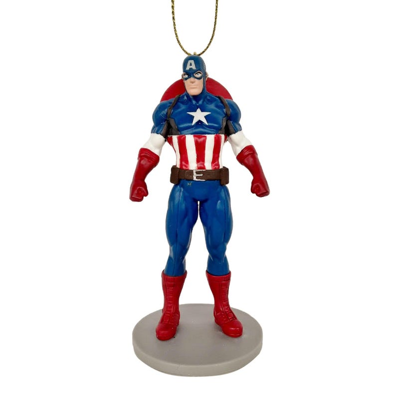 May include: A Captain America figurine, featuring a blue and red costume with a white star on the chest. The figurine has a red shield on the back and is mounted on a gray base. The figure is approximately 5 inches tall.