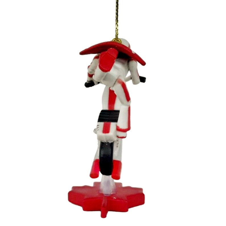 May include: A red and white Christmas ornament featuring a cartoon figure riding a motorcycle on a red maple leaf base.