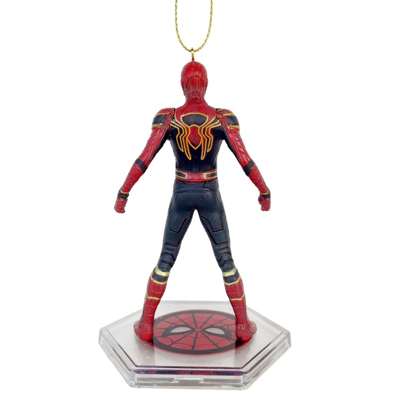 May include: A Spider-Man figure, viewed from the back, in a dynamic pose. The figure is predominantly red and black, with gold accents. It stands on a clear, hexagonal base with a Spider-Man emblem. A gold string is attached for hanging.