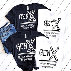 May include: Four t-shirts, two navy and two white, with the text "GEN X LOTS OF MEMORIES NO EVIDENCE" in a distressed font. A pair of blue jeans is visible in the image. The shirts are short-sleeved.