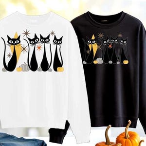 Puede incluir: Dos sudaderas, una blanca y otra negra, cada una con un gráfico de cinco gatos negros estilizados. Los gatos tienen ojos grandes y están colocados en fila, con calabazas y estrellas. La sudadera blanca tiene un triángulo amarillo detrás de los gatos.