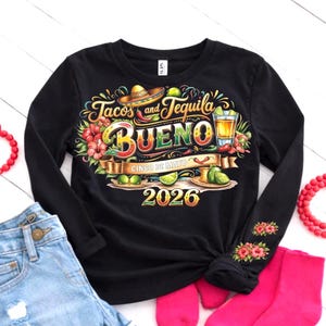 May include: Black long-sleeve shirt with a colorful graphic design. The design includes the words "Tacos and Tequila BUENO" with a sombrero, lime slices, and a shot of tequila. The year "2026" is also displayed. Floral accents adorn the sleeve.