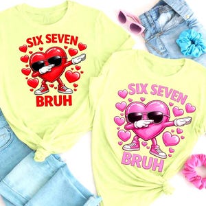 Puede incluir: Dos camisetas amarillo claro con diseños de corazón. Una camiseta tiene un corazón rojo con gafas de sol y haciendo dab, con el texto "SIX SEVEN BRUH". La otra camiseta tiene un corazón rosa con gafas de sol y la misma pose, con el mismo texto.