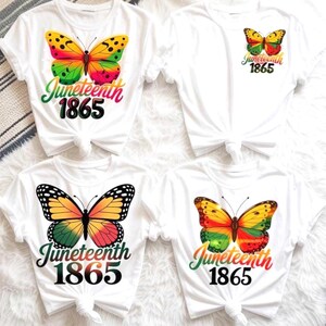May include: Four white t-shirts featuring butterfly graphics in red, yellow, and green. Each shirt displays the text "Juneteenth 1865" in a stylized font. The designs vary in size and placement, with some butterflies centered and others on the chest.