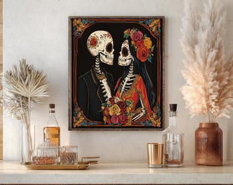 Può includere: Una stampa artistica incorniciata raffigurante una coppia di scheletri in abito formale, adornata con decorazioni floreali. L'opera presenta uno sfondo nero con colori vivaci, tra cui rosso, giallo e arancione, su una parete neutra.