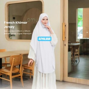 Può includere: Una donna indossa un French Khimar Jersey bianco. L'indumento è uno stile modesto e fluido, con un velo e una lunga gonna a strati. Il testo "ROYALJAVA" è visibile sull'indumento. Taglia Jumbo, 106cm x 135cm.