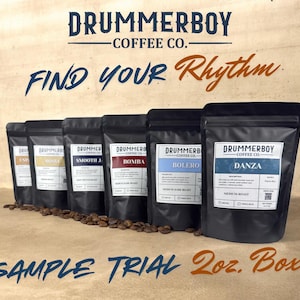 May include: A sample trial box of Drummerboy Coffee Co. coffee bags. The black bags have labels with coffee names like "Danza" and "Bolero". The text "Find Your Rhythm" is in the image. The box is labeled "Sample Trial 2oz. Box".