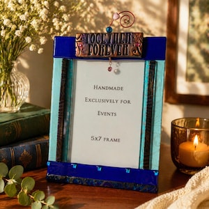 May include: A rectangular 5x7 picture frame featuring a deep blue and light blue glass border. The top of the frame displays a copper-toned plaque with the text "TOGETHER FOREVER" and a decorative wire swirl accent with small beads.