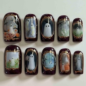 Può includere: Set di dieci unghie finte con scene di fantasmi per Halloween. Ogni unghia ha una base bordeaux scuro e bordi dorati. I dipinti in miniatura raffigurano fantasmi, alberi e zucche, con scene dettagliate.