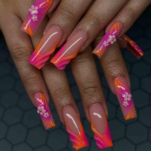 May include: Long, square-shaped acrylic nails with a French tip design. The nails feature a gradient of pink and orange, with floral and dot accents. Some nails have 3D flower embellishments.