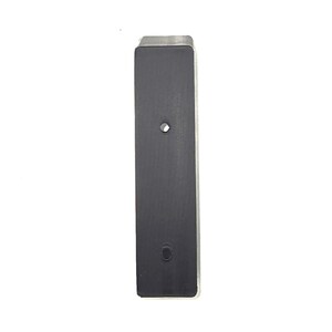 May include: A rectangular, black metal object with two circular holes. The top edge is silver. The object is set against a white background.