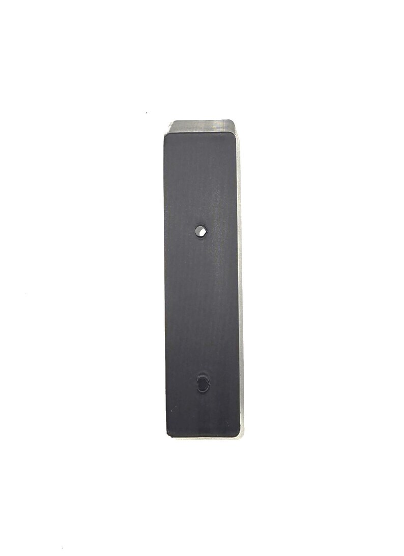 May include: A rectangular, black metal object with two circular holes. The top edge is silver. The object is set against a white background.