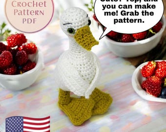 May include: A handmade white crochet goose with yellow feet and beak. The goose has green eyes and is sitting on a surface. Text in a speech bubble says, "Cute? Yep, and you can make me! Grab the pattern." The image also includes the text "Crochet Pattern PDF."