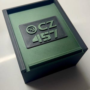 May include: A green and black plastic box with a label that reads "CZ 457".