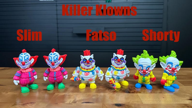 Puede incluir: Seis figuras de Killer Klowns etiquetadas como Slim, Fatso y Shorty. Las figuras presentan trajes de payaso de colores vibrantes con detalles en rojo, amarillo, verde y azul. Cada personaje tiene rasgos faciales, colores de pelo y poses distintos sobre una superficie de madera.