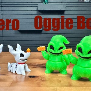 Puede incluir: Dos figuras de perro fantasma blancas con collares rojos y peque&ntilde;as narices de calabaza naranja, junto a dos figuras de Oogie Boogie verde brillante que sostienen dados naranjas. El texto Zero y Oogie Boogie aparece en rojo.