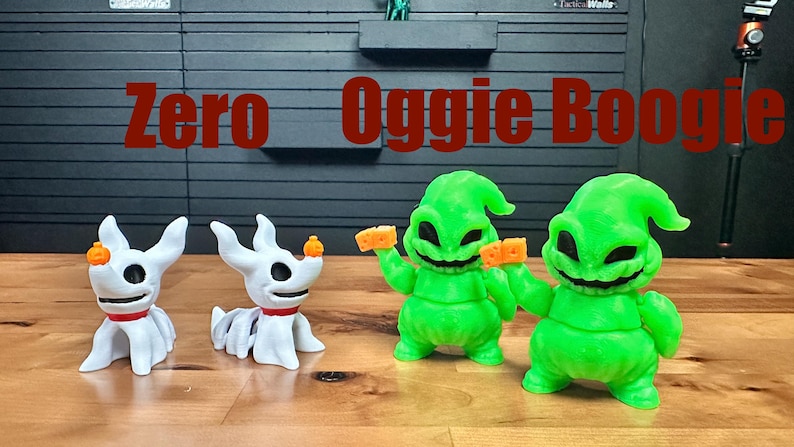 Puede incluir: Dos figuras de perro fantasma blancas con collares rojos y peque&ntilde;as narices de calabaza naranja, junto a dos figuras de Oogie Boogie verde brillante que sostienen dados naranjas. El texto Zero y Oogie Boogie aparece en rojo.