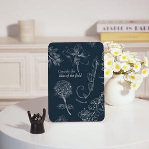 May include: A navy blue phone case with a white floral design and the text "Consider the lilies of the field" and "Matthew 6:28".