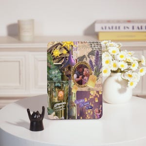 May include: A rectangular decorative piece featuring a collage of images from a fairytale. The collage includes a framed image of a couple, a purple tower, and the text "I'm where I'm meant to be."