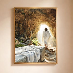 Puede incluir: Una obra de arte enmarcada representa una figura con túnicas blancas saliendo de una cueva iluminada. La escena incluye una tumba de piedra con tela blanca drapeada, sobre un fondo de terreno rocoso y vegetación exuberante. La obra está enmarcada en un marco dorado.