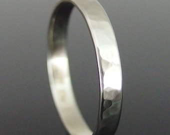 May include: A silver hammered band ring. The ring is simple and has a smooth, polished finish.